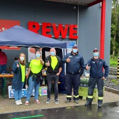 Teilnehmer der Hilfsaktion vor dem REWE Markt