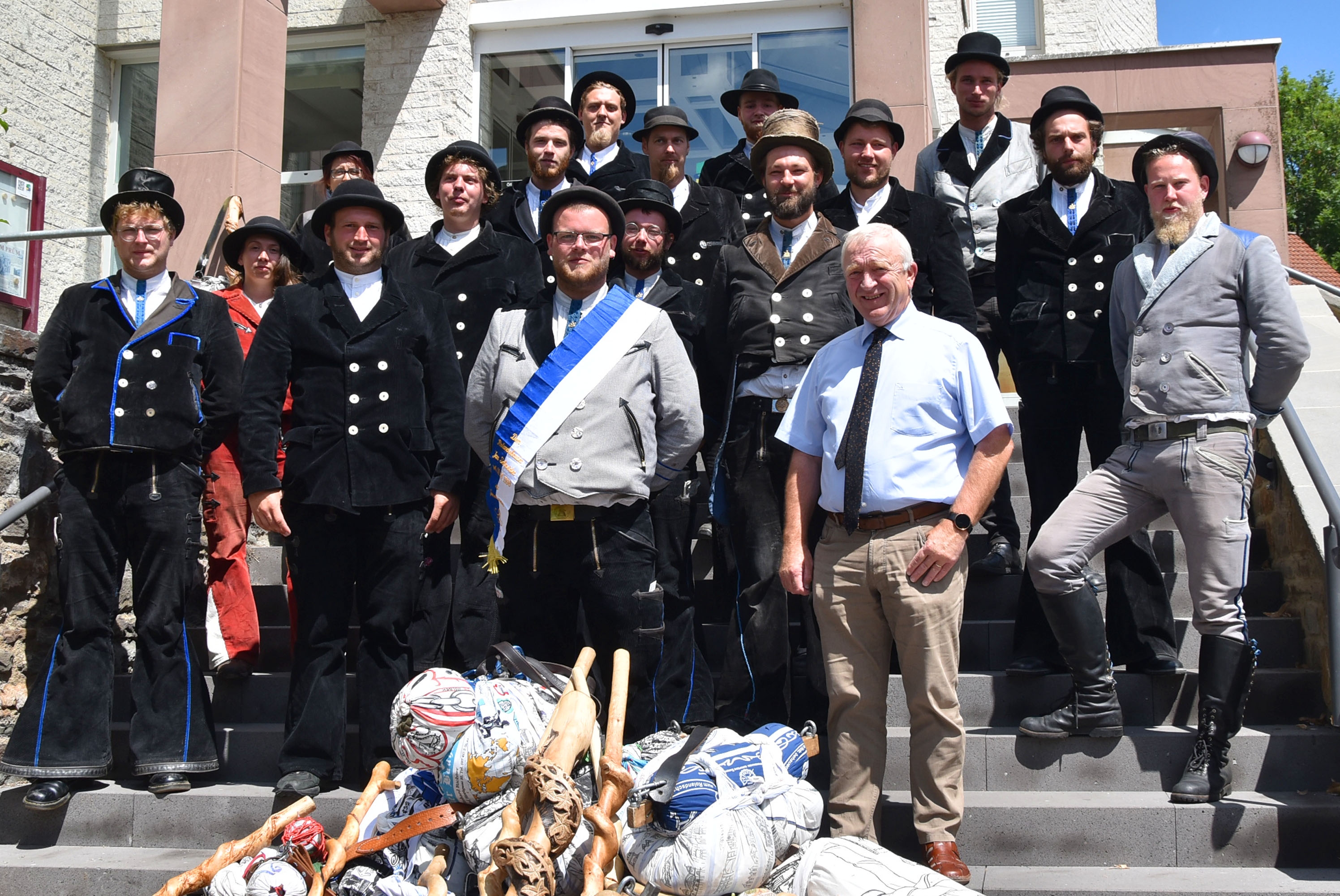 Gruppenbild der zwei Wandergesellinnen und 14 Wandergesellen mit Bürgermeister Aloysius Söhngen