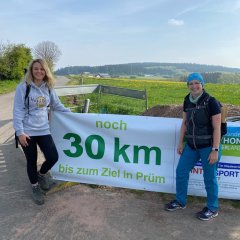 Teilnehmer des Wandermarathons vor Schild, dass es in 30 km geschafft ist