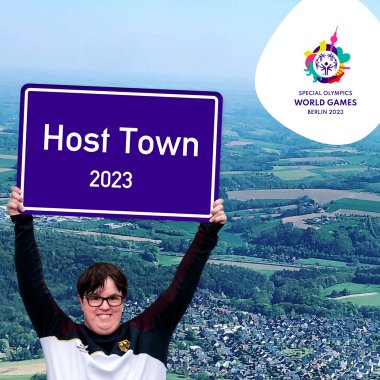 Person, die Schild Host Town 2023 hochhält