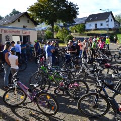 Teilnehmer und geparkte Fahrräder am Feuerwehrhaus Lasel