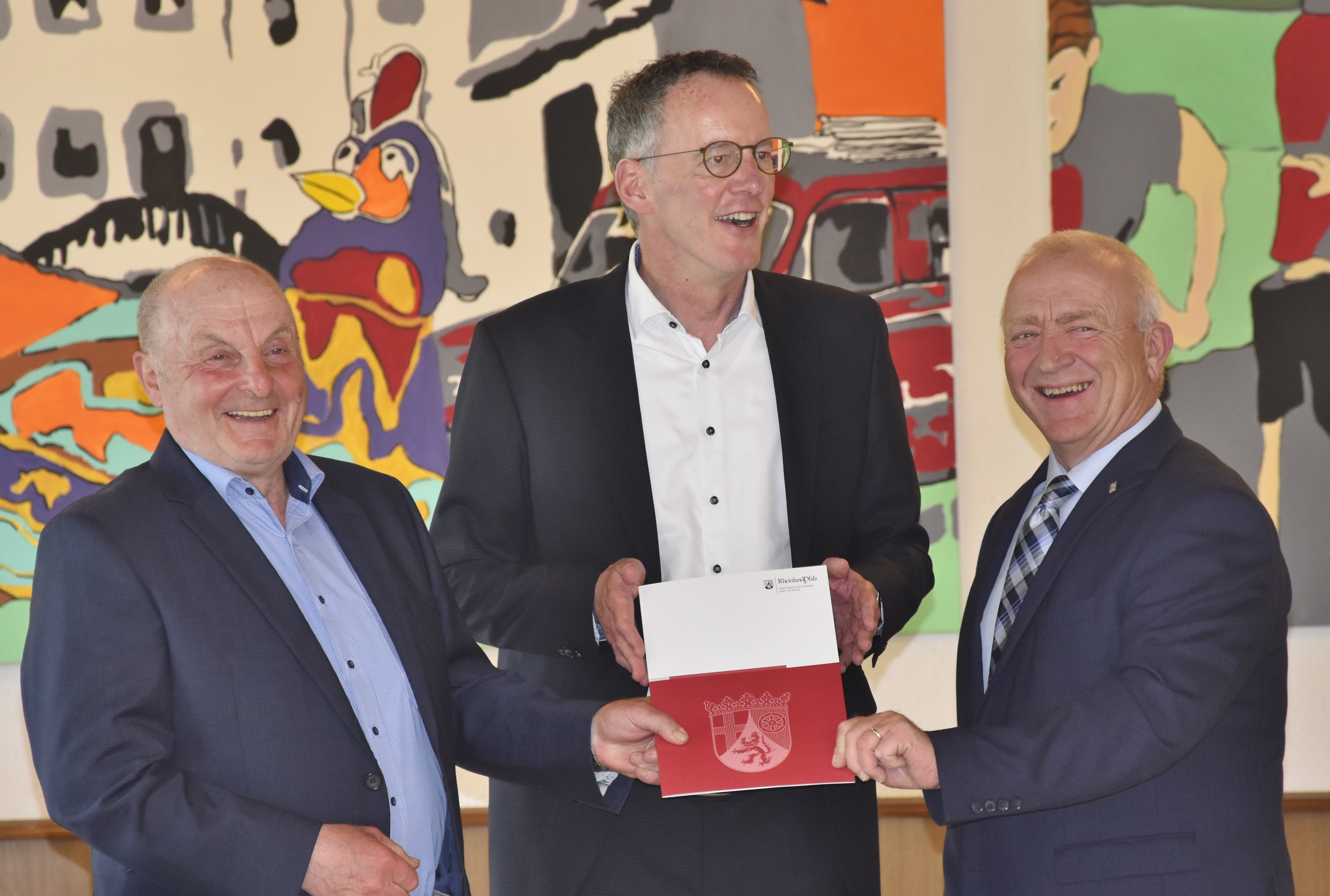 li. Ortsbürgermeister Karl Hansen, Innenminister Michael Ebling und re. Bürgermeister Aloysius Söhngen bei der Übergabe des Förderbescheids an die Ortsgemeinde Hersdorf