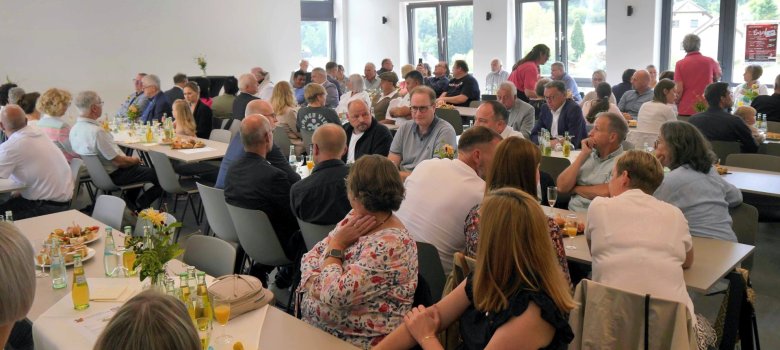 Gemeindehaus mit Besuchern, die am Tisch sitzen