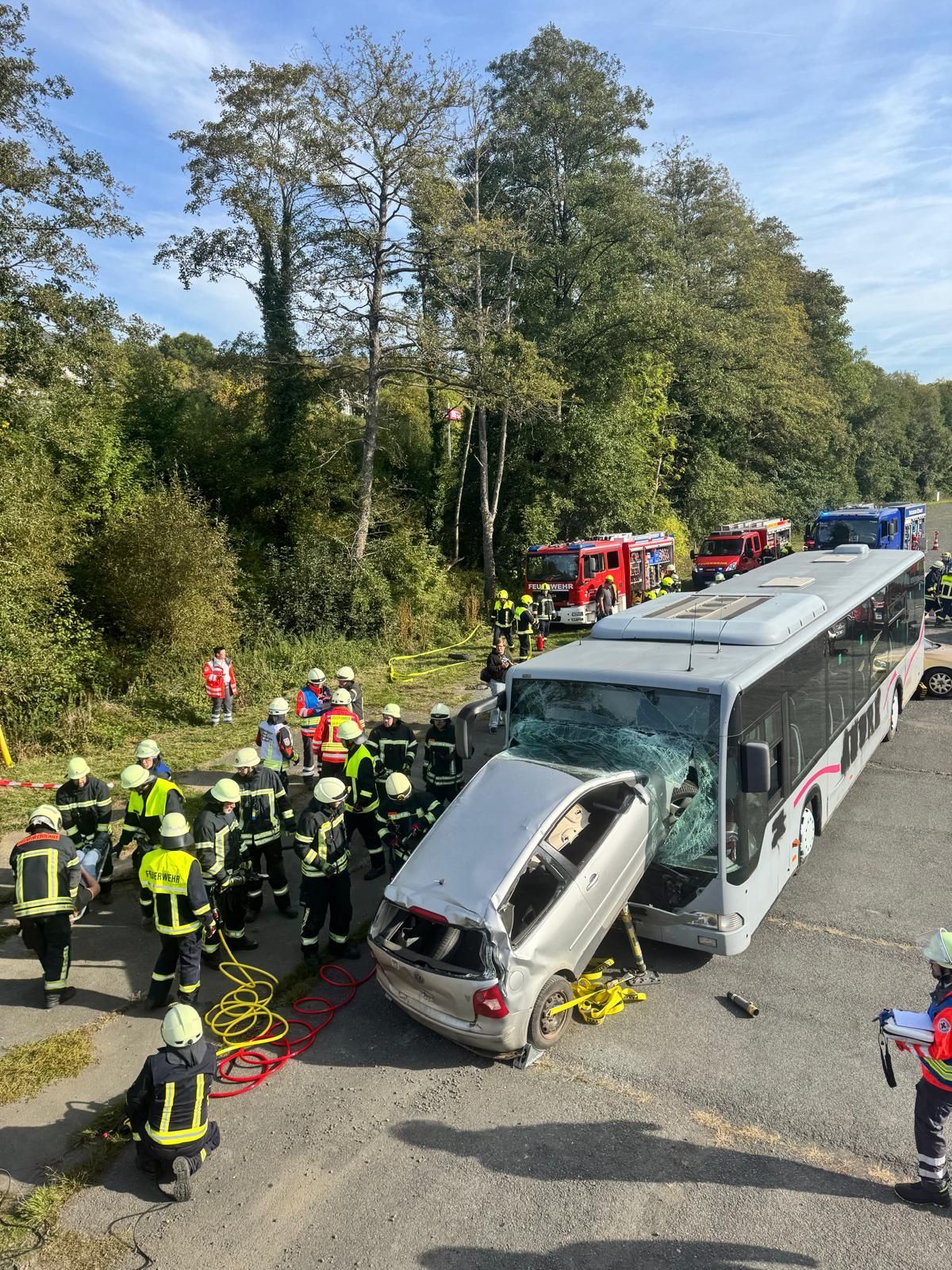 Simulierter Verkehrsunfall wo ein Auto in einen Bus gefahren ist. Rund um die simulierte Unfallstelle sieht man Helfer bei der Bergung.