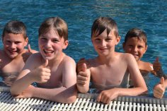Kinder im Freibad am Beckenrand